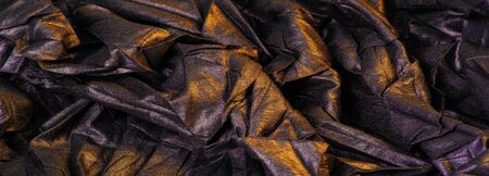 texture background pattern wallpaper silk fabric black with yellow golden stripes, wrinkled fabric, your project will acquire sophistication and brevity this unusual texture is exactly what you needの写真素材