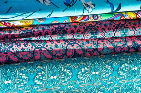 Texture background, pattern. Different fabrics stacked on a table in a pileの写真素材