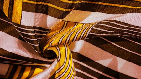 Texture, background, silk fabric with a yellow striped pattern. The design of this fabric is dedicated to a white rabbit mosaic representing the look of a fabulous vest.の写真素材