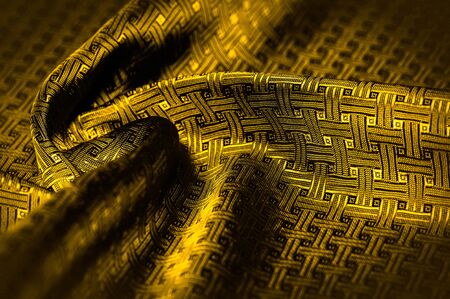 Background texture, pattern. Yellow, mustard silk fabric with a small checkered pattern. Muffled...