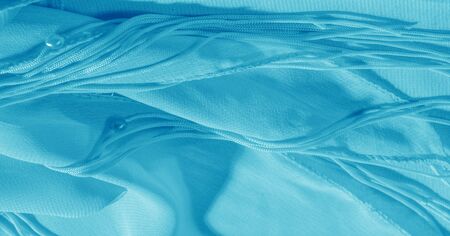 The background, pattern, texture, wallpaper, blue pale silk fabric has a brilliant shine. This is...