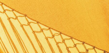 Background texture of silk fabric. This is a natural yellow scarf, this beautiful nylon satin made...