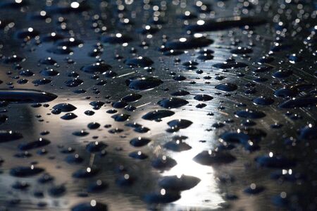 summer rain, drops of water on the car paint. a small round or pear-shaped portion of liquid that hangs or falls or adheres to a surface.の写真素材