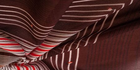Texture, pattern, collection, silk fabric, brown background with a striped pattern of white and red lines, the Spanish theme, which is great for the design of procedures and projects.の写真素材