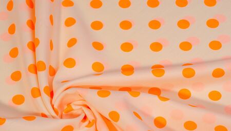 Textured background, orange polka dot silk fabric. This versatile fabric is perfect for creating stylish design projects. Colors include orange and white.の写真素材