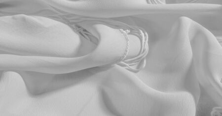 Background, pattern, texture, wallpaper, white silk fabric has a brilliant shine. This is the most versatile fabric. Be creative with beautiful accents of your design.の写真素材