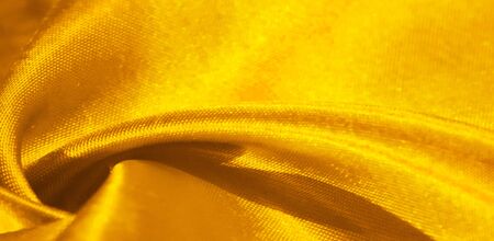 Texture, background, pattern, silk fabric in yellow. This adorable, soft and shiny fabric has a smooth mink surface, perfect for creating your projects.の写真素材