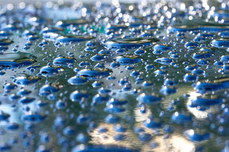 summer rain, drops of water on the car paint. a small round or pear-shaped portion of liquid that hangs or falls or adheres to a surface.の写真素材