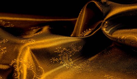 Texture background pattern Yellow mustard brown chiffon fabric with paisley print High quality pure silk chiffon fabric bright beautiful color combinations This fabric is suitable for design wallpaperの写真素材