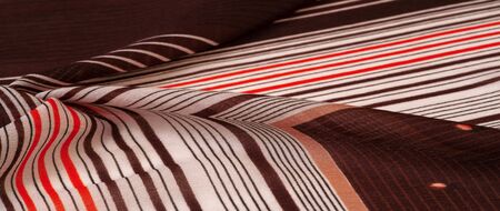 Texture, pattern, collection, silk fabric, brown background with a striped pattern of white and red lines, the Spanish theme, which is great for the design of procedures and projects.の写真素材