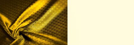 Background texture, pattern. Yellow, mustard silk fabric with a small checkered pattern. Muffled...