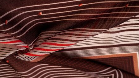 Texture, pattern, collection, silk fabric, brown background with a striped pattern of white and red lines, the Spanish theme, which is great for the design of procedures and projects.の写真素材