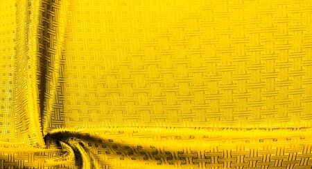 Background texture, pattern. Yellow, mustard silk fabric with a small checkered pattern. Muffled...
