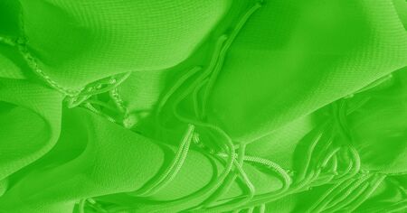 The background, pattern, texture, wallpaper, green pale silk fabric has a brilliant shine. This is the most versatile fabric. Be creative with beautiful accents of your design.の写真素材