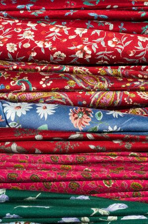 Texture background, pattern. Different fabrics stacked on a table in a pileの写真素材