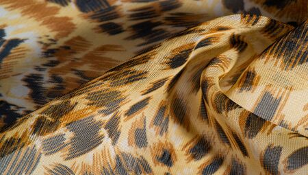 background pattern African fabric with silk print with tiger print. This amazing fabric will help you to plunge into the world of unbridled savannah. You will be sensual with design projectsの写真素材