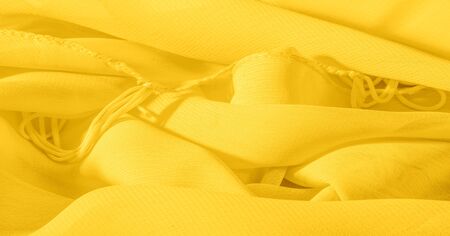 The background, pattern, texture, wallpaper, yellow pale silk fabric has a brilliant shine. This is the most versatile fabric. Be creative with beautiful accents of your design.の写真素材