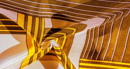 Texture, background, silk fabric with a yellow striped pattern. The design of this fabric is dedicated to a white rabbit mosaic representing the look of a fabulous vest.の写真素材
