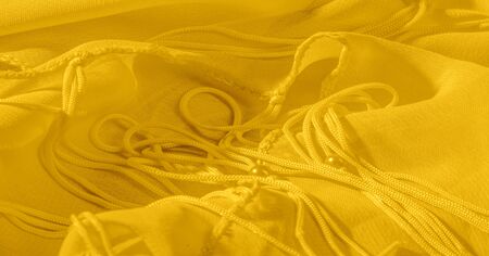 The background, pattern, texture, wallpaper, yellow pale silk fabric has a brilliant shine. This is...