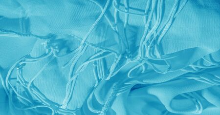 The background, pattern, texture, wallpaper, blue pale silk fabric has a brilliant shine. This is...