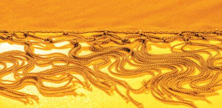 Background texture of silk fabric. This is a natural yellow scarf, this beautiful nylon satin made...