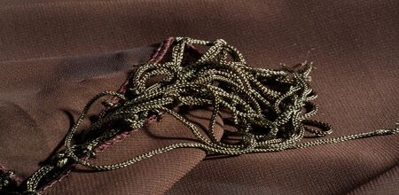 Background texture of silk fabric. This is a natural brown scarf, this beautiful nylon satin made of...