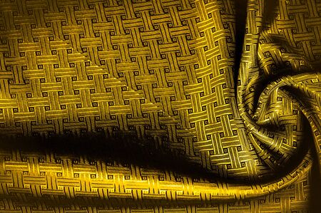 Background texture, pattern. Yellow, mustard silk fabric with a small checkered pattern. Muffled...