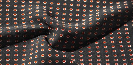 Texture background, pattern,  black silk fabric with red polka dots. Light and silky-soft satin...