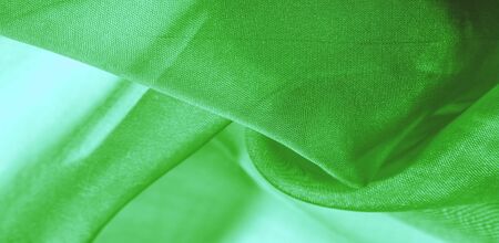 Texture of green silk fabric. It is also perfect for your design, clothes, posters. Be creative with beautiful project accents. This fabric is inspired by your inspiration.の写真素材