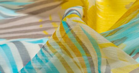 texture background pattern. Silk fabric with colored lace. Yellow blue and gray-blue shades. It is...