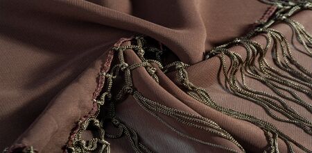 Background texture of silk fabric. This is a natural brown scarf, this beautiful nylon satin made of...