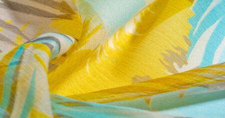 texture background pattern. Silk fabric with colored lace. Yellow blue and gray-blue shades. It is...