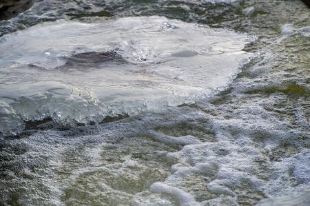 Winter landscape, ice on the spring, frozen water, a brittle, transparent crystalline solid. source,...