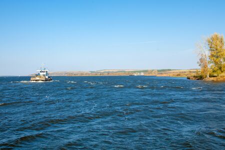 Autumn landscape, river, Works carried out on the river, riverboats, sunny day, wind raises the...