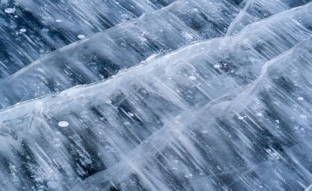 There is frost on the street, ice on the river, ice bubbles stuck in ice, unusually colorful ice architectureの写真素材