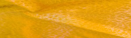 The texture, background, pattern, white yellow silk fabric is textile. Its properties differ from the woven material in that it is more flexible and easier to design.の写真素材