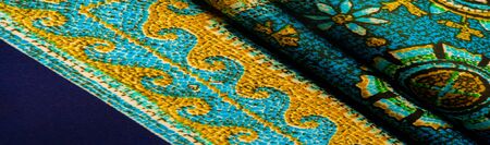 Texture background design, turquoise silk fabric with yellow drawings of flowers circles. Charmeuse...