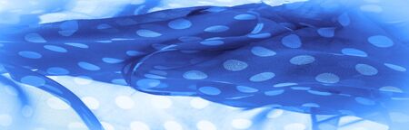 Background texture, decorative ornament, blue polka-dot silk fabric, round dots on fabric that have a shape or approximately resemble a circle or cylinder.の写真素材