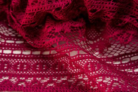 Background, texture, pattern, red lace fabric, thin open fabric, usually made of cotton or silk, made using loops, twisting or knitting threads in patternsの写真素材