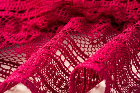 Background, texture, pattern, red lace fabric, thin open fabric, usually made of cotton or silk, made using loops, twisting or knitting threads in patternsの写真素材