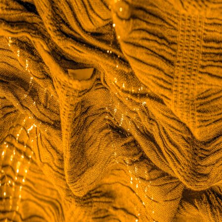 The texture of the background pattern, ornament decor, golden yellow corrugated fabric, fabric with parallel or diagonal folds of serrated folds; products from such a fabric.の写真素材