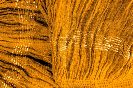 The texture of the background pattern, ornament decor, golden yellow corrugated fabric, fabric with parallel or diagonal folds of serrated folds; products from such a fabric.の写真素材