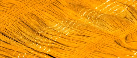 The texture of the background pattern, ornament decor, golden yellow corrugated fabric, fabric with parallel or diagonal folds of serrated folds; products from such a fabric.の写真素材
