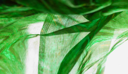 Background texture, pattern. Silk from a greenish emerald shade. This luxurious silk chiffon fabric...