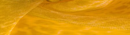 The texture, background, pattern, white yellow silk fabric is textile. Its properties differ from the woven material in that it is more flexible and easier to design.の写真素材