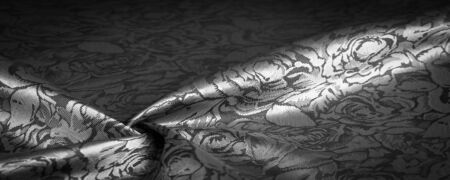 relief pattern, composite textile, silk fabric in black and white, with a floral pattern, unusually pleasant visual sensations: slippery, coolness, softness; beautiful appearance, unique shineの写真素材