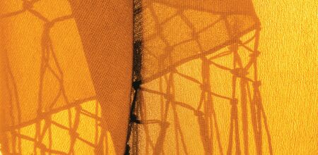 Background texture of silk fabric. This is a natural yellow scarf, this beautiful nylon satin made of rayon with a transparent hand and a wonderful sheen is perfect for your projects.の写真素材