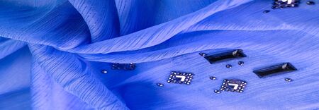 Background design texture, silk pattern, blue fabric with glued decorative faceted stonesの写真素材