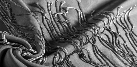 Background texture of silk fabric. This is a natural black scarf, this beautiful nylon satin made of rayon with a transparent hand and a wonderful sheen is perfect for your projects..の写真素材