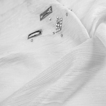 Background design texture, silk pattern, White fabric with glued decorative faceted stonesの写真素材